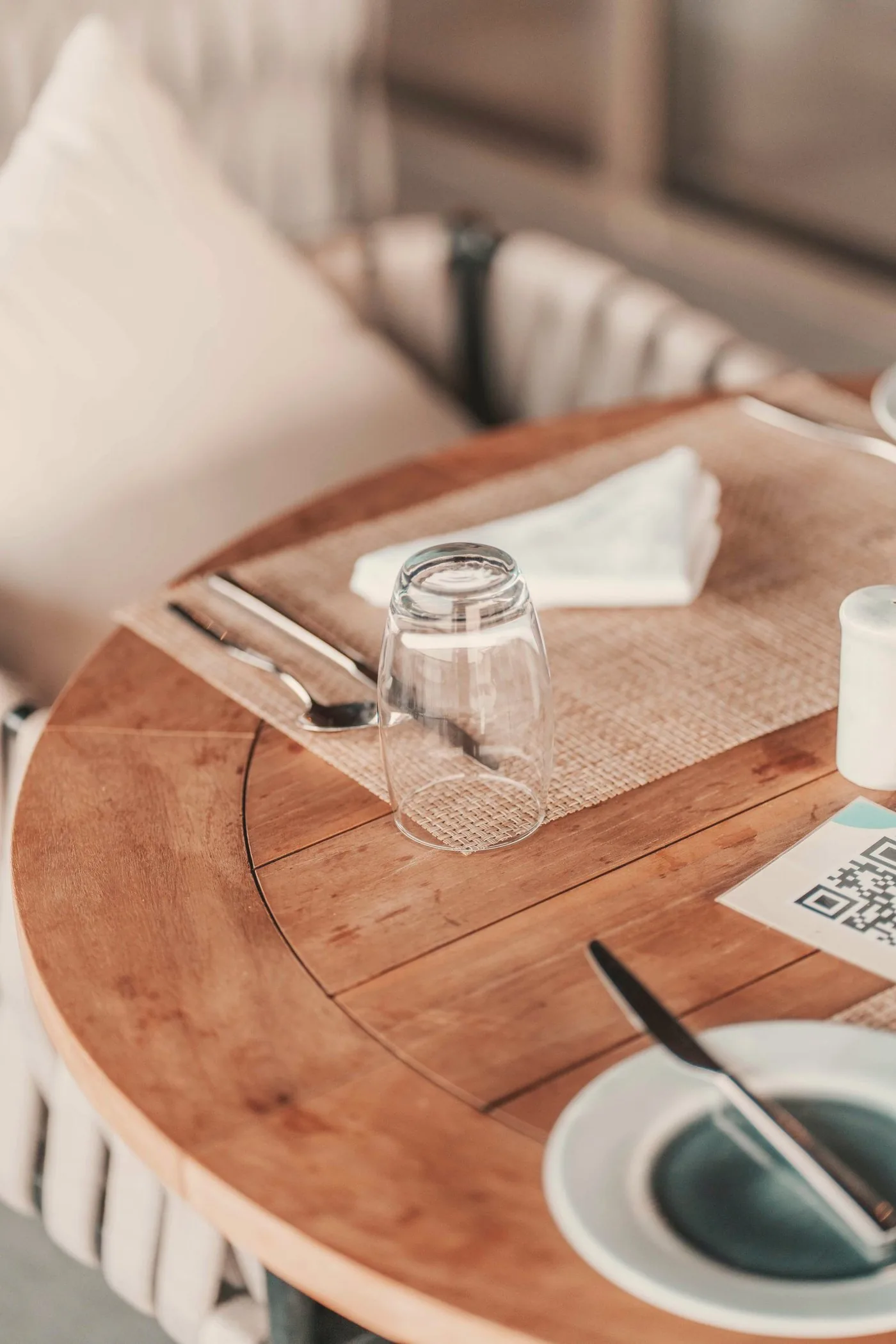 Un código para acercar el móvil sobre una mesa de madera de restaurante.